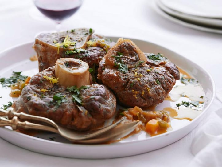 Osso Buco on a white plate in a bright lit room