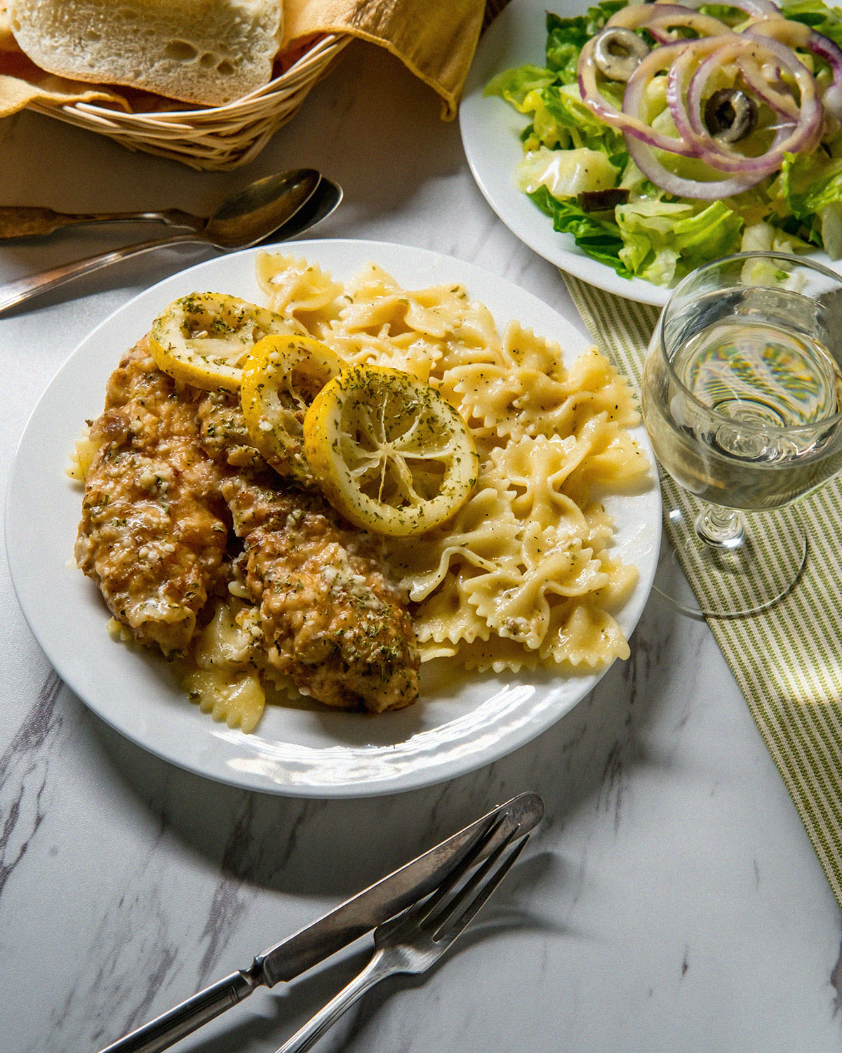 chicken francese with salad on dinner table