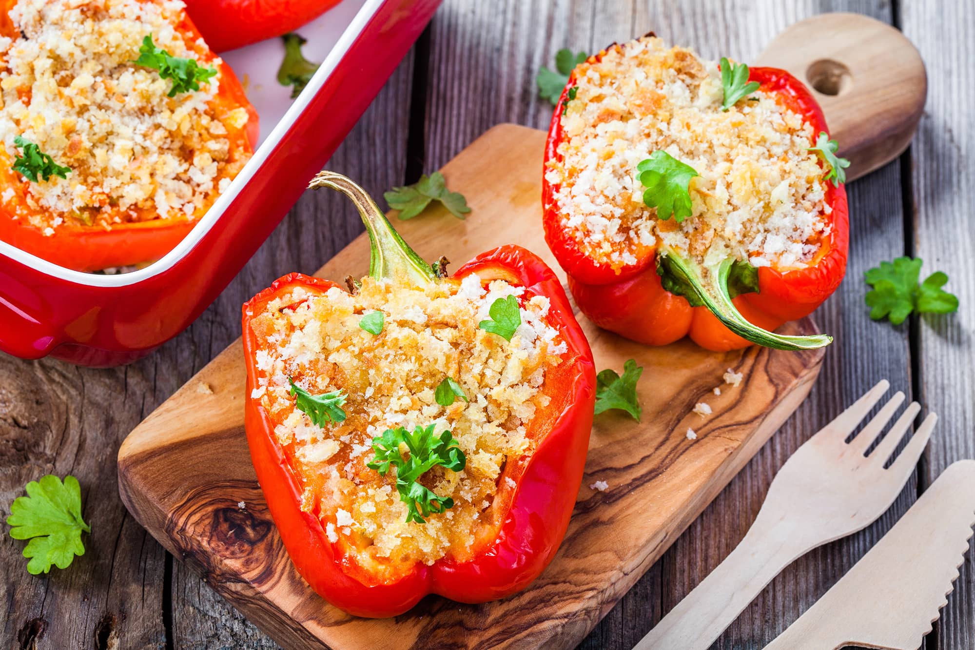 Vegetarian Stuffed Peppers on cutting board with cutlery on the side