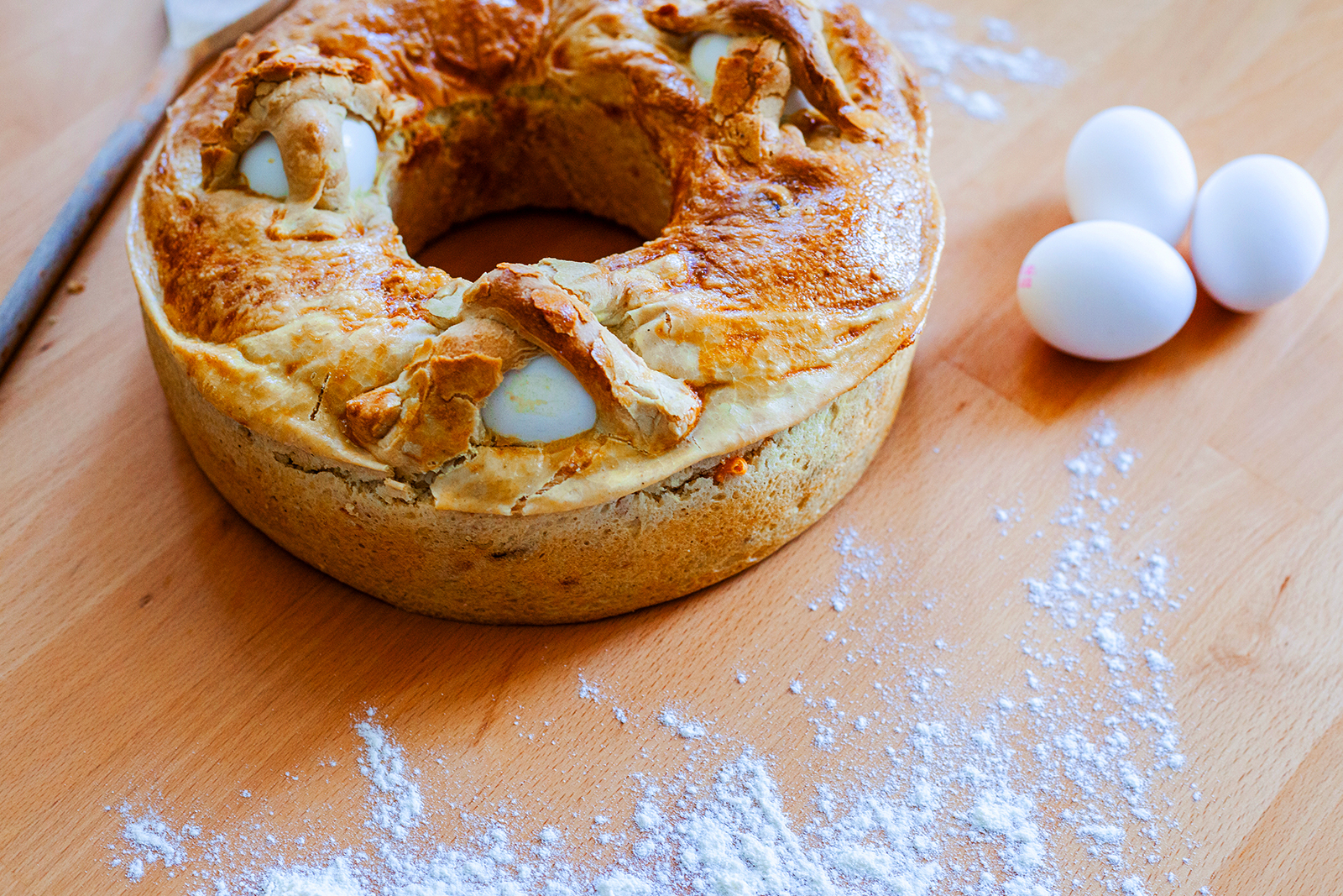 Casatiello o tortano napoletano on table with powdered sugar sprinkled around