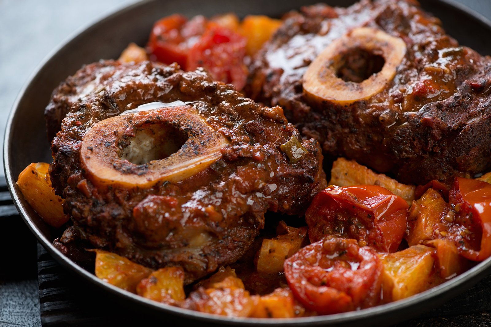 Closeup of osso buco made of cross cut veal shank with oranges and tomatoes