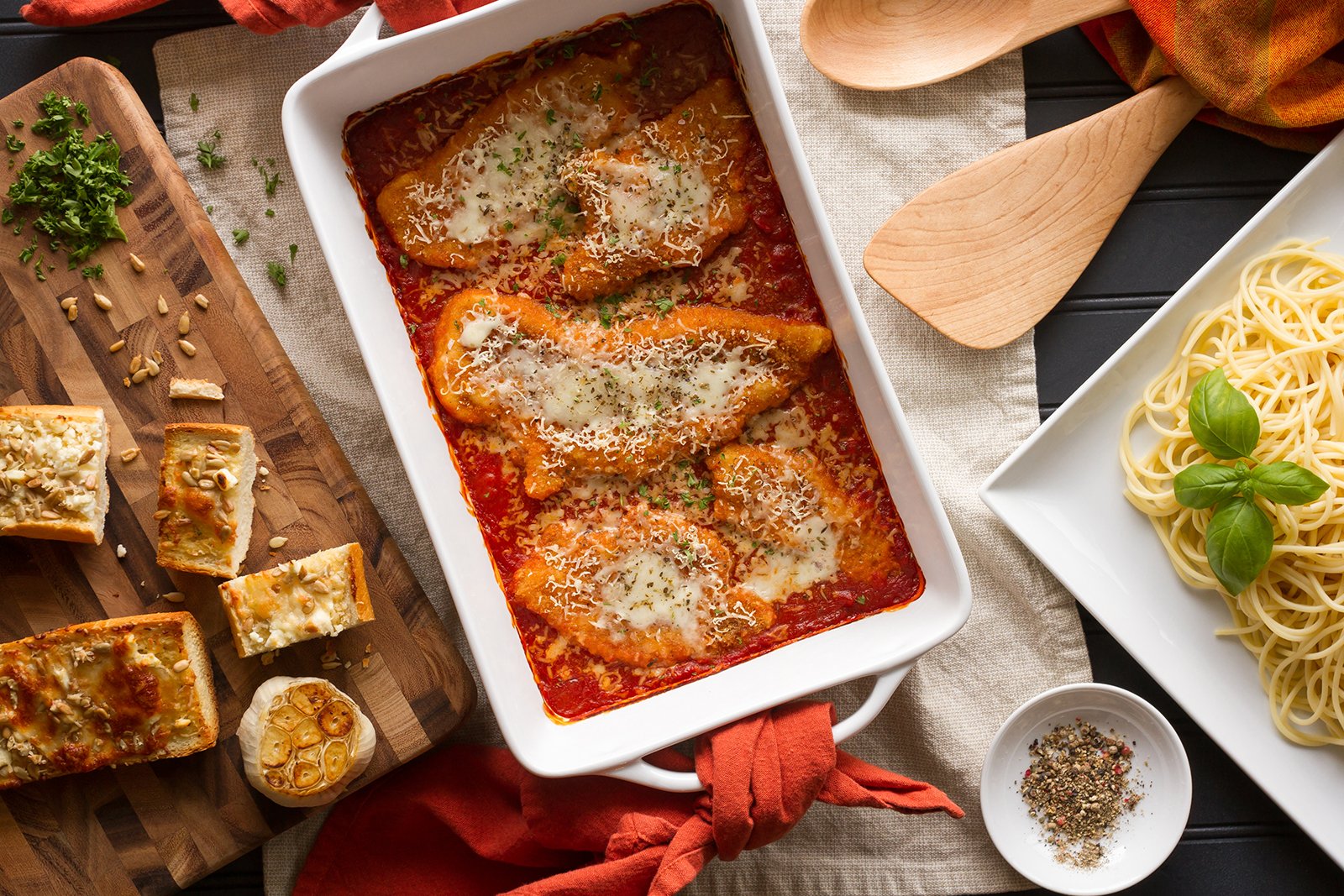 Dish with Chicken Parmigiana and Garlic Bread to the left