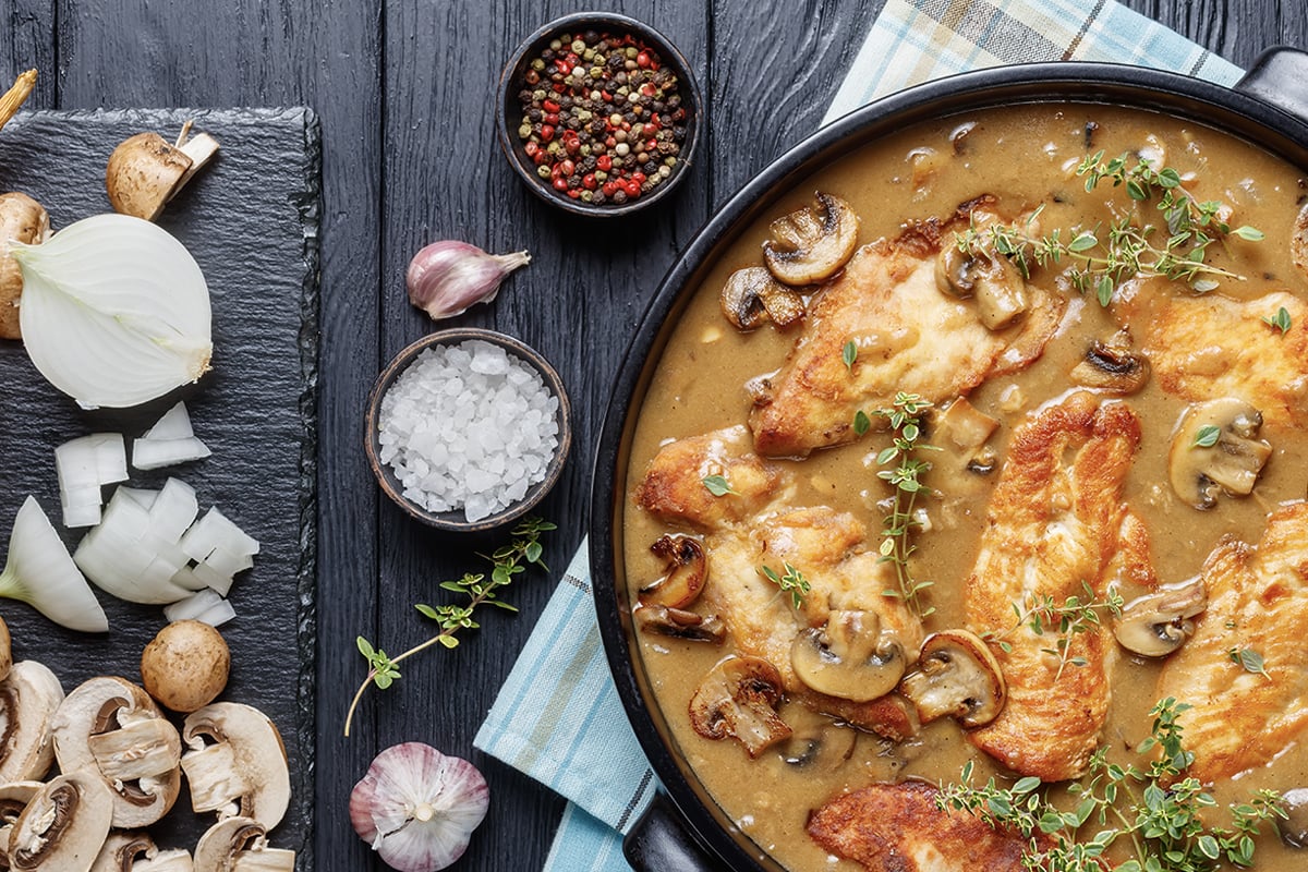 Chicken marsala in a pot with ingredients laying to the right