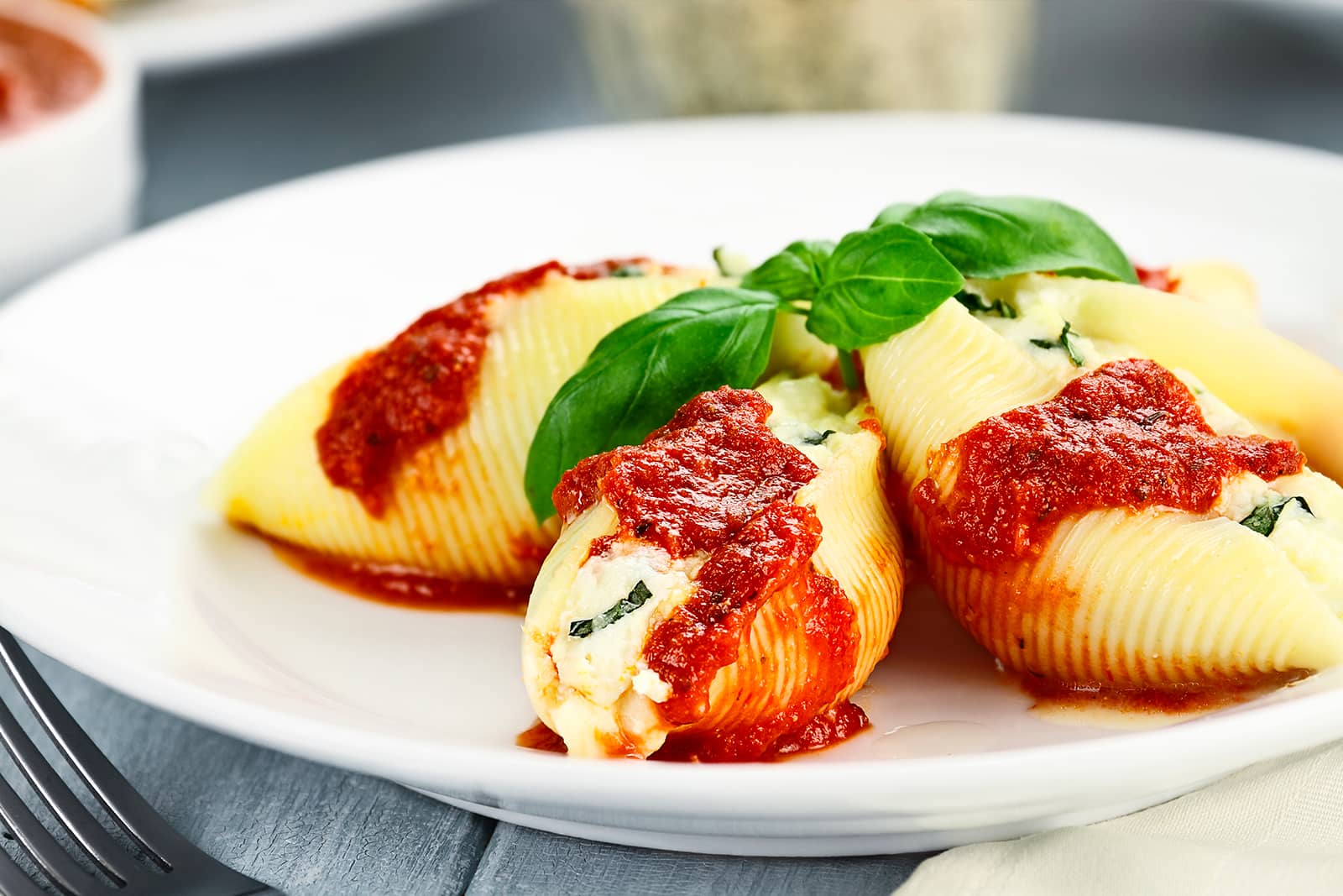 Close-up of Four Perfect Stuffed Shells on white plates