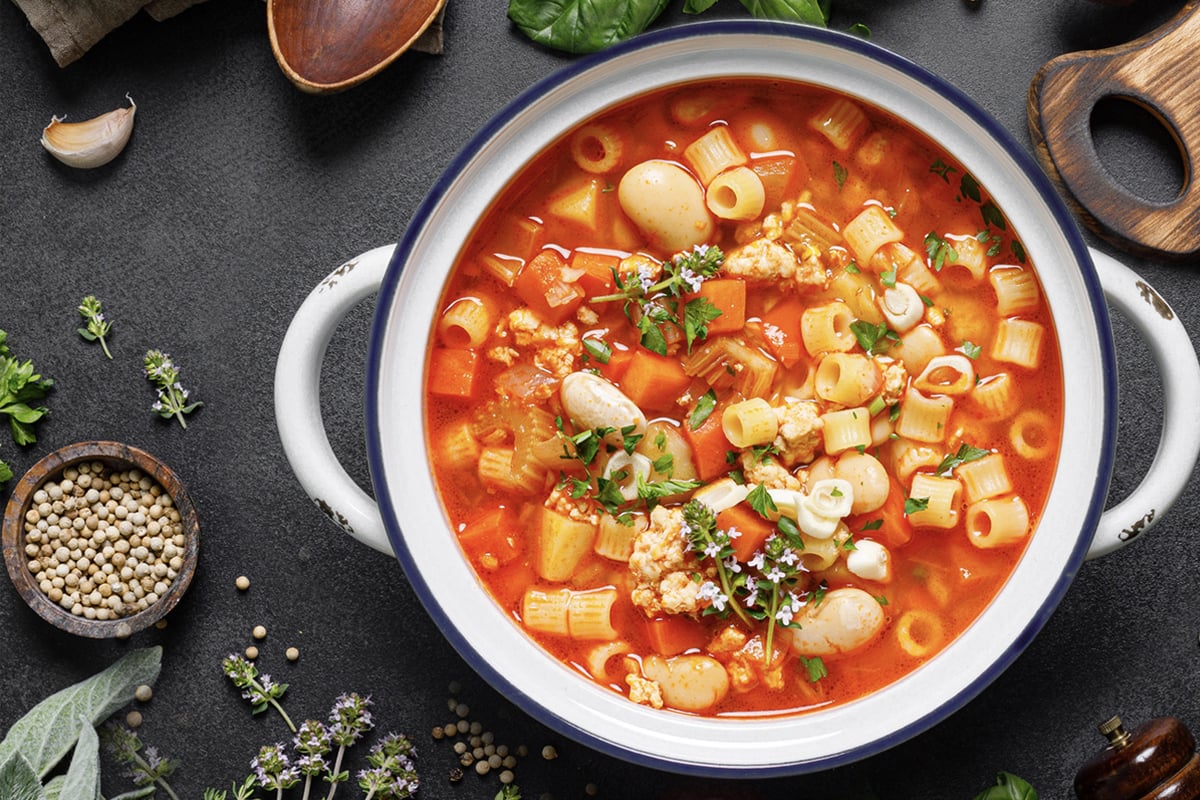 Close up of Overhead shot of Pasta e Fagioli dish with other cooking items around it