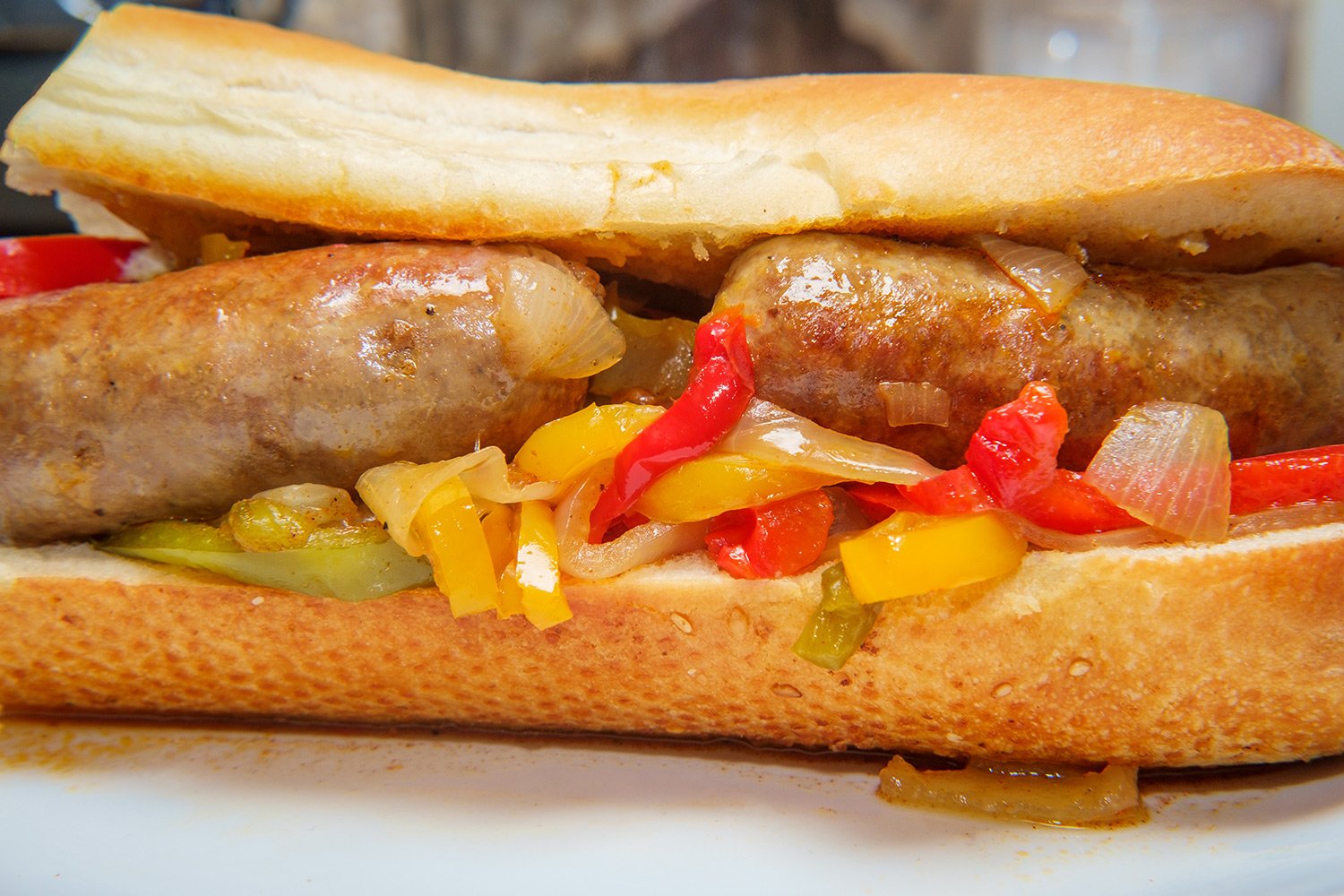 upclose shot of sausage and peppers on a hero sandwich